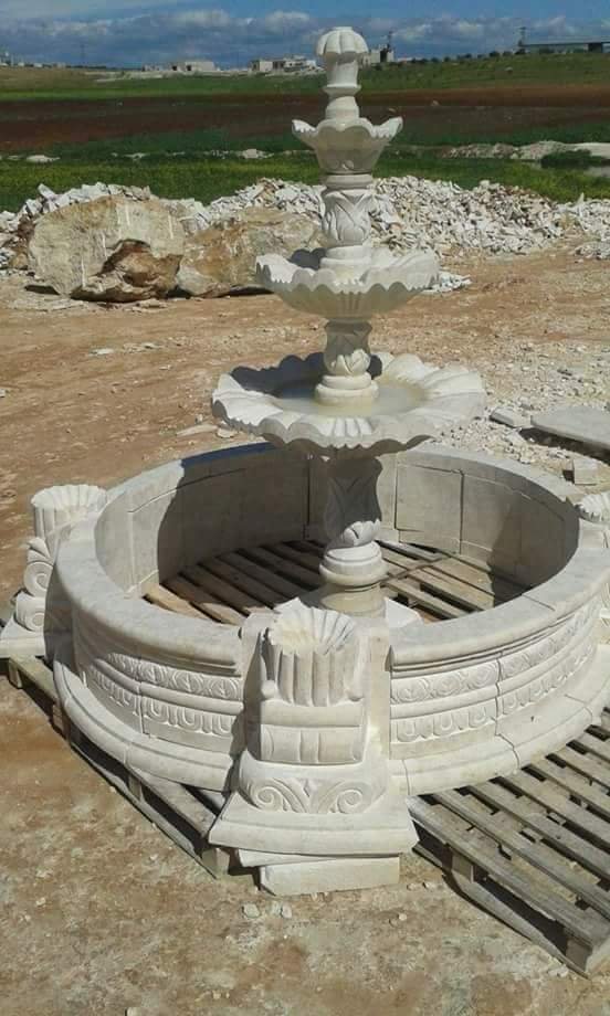 A large fountain basin being carved in the yard